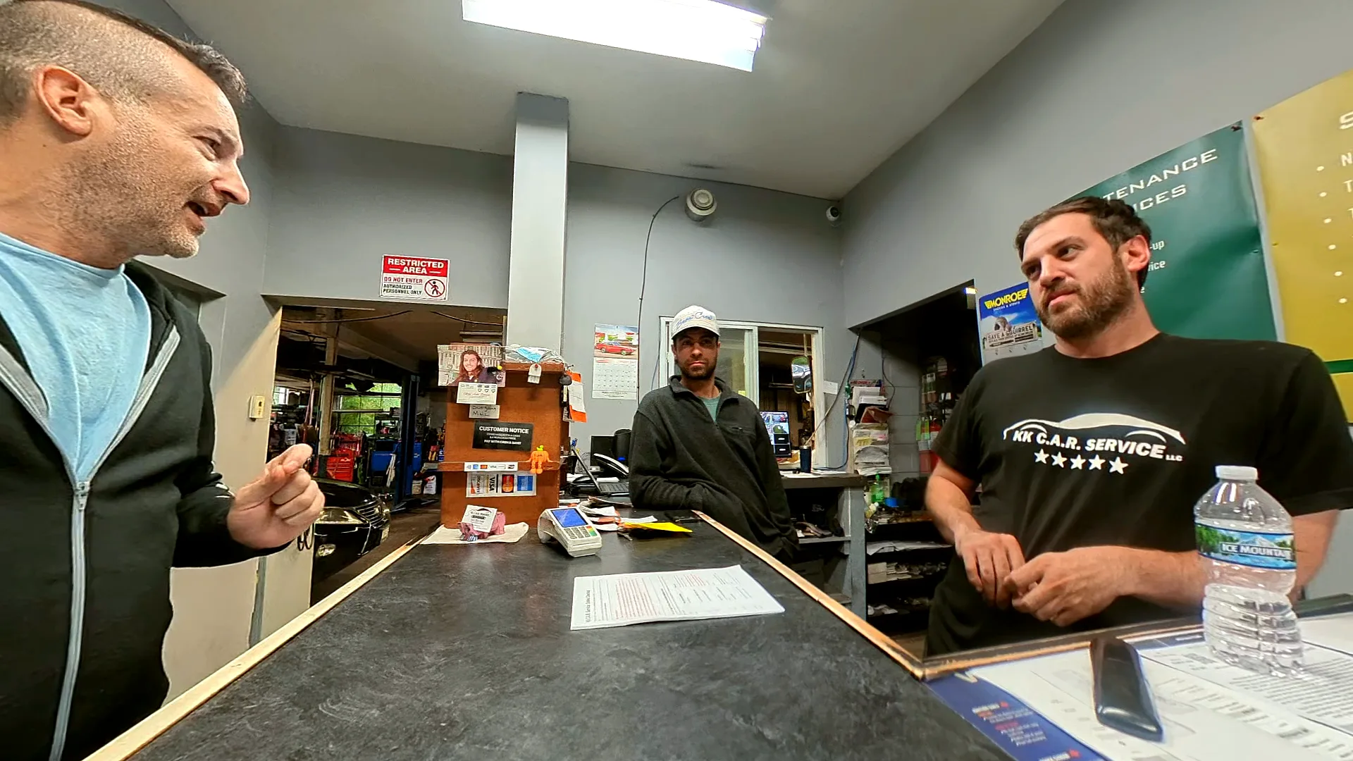 Nick Poulos, owner of KK Car Service, at his shop counter